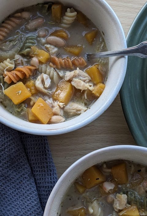 Fall butternut squash chicken noodle soup dished up with side salad and breadsticks