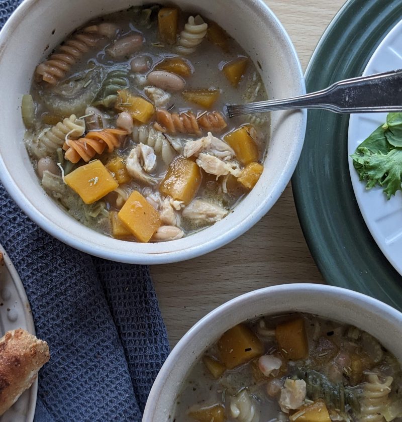 Fall butternut squash chicken noodle soup dished up with side salad and breadsticks