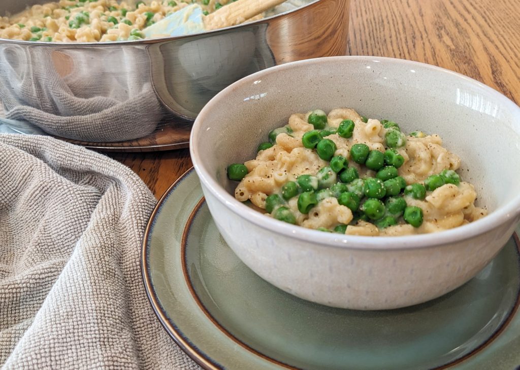 bowl of macaroni and cheese with peas